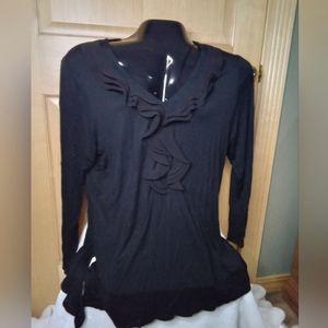 Women's longer black shirt with ruffled front.